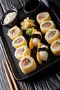 Set tamagoyaki sushi roll with rice, cheese, salmon and avocado closeup on a plate. vertical
