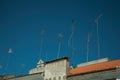 Set of television antennas on top of roof with blue sky