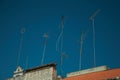 Set of television antennas on top of roof with blue sky