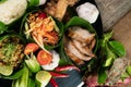 Set of Thai style food with rice, minced pork, papaya salad, pork steak and spare ribs served in banana leaves Royalty Free Stock Photo