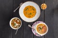 Set of three bowls with different soups combo menu on black wooden table Royalty Free Stock Photo