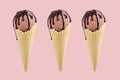 Set of three brown ice cream in crisp waffle cones with chocolate sauce on pastel pink background, mock up. Royalty Free Stock Photo