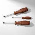 Set of Three Different Sized Flathead Screwdrivers with Brown Handles on White Background. Royalty Free Stock Photo