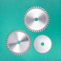 Set of three discs with carbide teeth for a table saw on a green background Royalty Free Stock Photo
