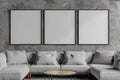 Set of three empty frames for wall art mock up. Modern living room with grey couch and coffee table Royalty Free Stock Photo