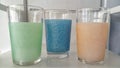 A set of three exotic drinking glasses in green, blue and orange colors