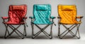 A set of three foldable camping chairs in blue, red, and yellow is isolated on a transparent background, representing Royalty Free Stock Photo