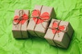 Set of three gift boxes tied with a rope on green crumbled paper background. Carton hearts cards.