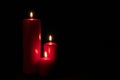 Set of three red candles burning in the dark Royalty Free Stock Photo