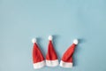 Set of three Santa Claus hats on a light blue background. Christmas or New Year concept. Minimalism. Copy Space