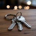 A set of three silver metal keys on a wooden surface, attached to a circular keyring.