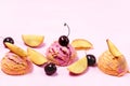 Set of three Various Ice Cream Balls or Scoops Decorated with Fruits on Pink Background Top View Peach and Cherry Flavor