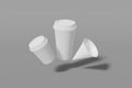 Set of three white paper mockup cups of different sizes - large, small and cone shaped fly on a grey background. 3D rendering Royalty Free Stock Photo