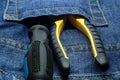 Set tool in a jeans pocket screwdriver pliers rubber handles close-up construction hand tools Royalty Free Stock Photo