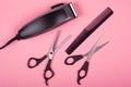 Set of tools for haircuts on a pink background, scissors, comb and trimmer Royalty Free Stock Photo