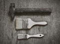 Set of tools: a large brush to paint a small brush to paint and old hammer nails on wooden background. Royalty Free Stock Photo