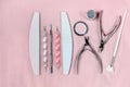 Tools for manicure and pedicure with dotting pens on light rose background