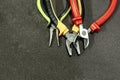 Set of tools nippers bright handles red yellow open dark background