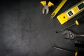 Yellow hardware tools on black concrete background with some space for text