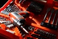 Set of tools in an orange case including a power screwdriver, driver bits, spade bits, and drill bits lit up by the sun Royalty Free Stock Photo