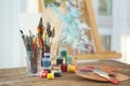 Set of tools and paints of professional artist on table in workshop