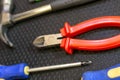 Set of tools red nippers screwdriver blue hammer dark background close up