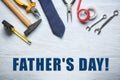 Set of tools with tie on light wooden background. Father's Day celebration Royalty Free Stock Photo