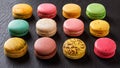 Set of twelve multicolored macaroons on a black background. Dozen of colorful macaron cakes variety. Delicious french dessert.