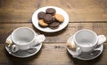 Set of two ceramic tea mugs with tea bags and plates of cookies.Preparation for brewing tea. Royalty Free Stock Photo