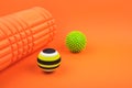 Set of two myofascial release and massage balls, bumpy foam massage roller for trigger points over orange background Royalty Free Stock Photo