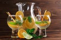 Exotic lemonade with mint and oranges. Party glasses of fruity rum on a wooden background. Fresh cocktails at the bar. Royalty Free Stock Photo