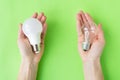 A set of two types of lamps, LED and incandescent, in the hands of a girl isolated on a green background. Energy-saving lamps Royalty Free Stock Photo