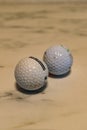 Set of two used dirty golf balls on a marble plate Royalty Free Stock Photo