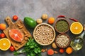 Set uncooked healthy balanced food, salmon,legumes, fruits, vegetables, olive oil and nuts, dark rustic background. Overhead view