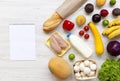 Set of variety fresh healthy food with paper for notes on white wooden backfround, view from above. Grocery plan concept. Royalty Free Stock Photo
