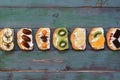 Set of a variety of sweet sandwiches on a green wooden plank background. Top view, place for text Royalty Free Stock Photo