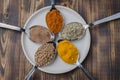 Set of various aromatic colorful spices in spoons on a in a bowl on a wooden table. Top view