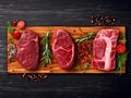 Set of various beef and veal raw steak meat on wooden cutting board on dark wooden table. Chateau mignon, striploin, tenderloin,