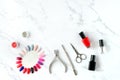 Set of various manicure and pedicure tools and accessories on white marble background. Top view Royalty Free Stock Photo