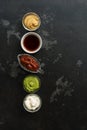 Set of various sauces in bowls in a row on a black stone background. Mustard sauce, tomato, wasabi, mayonnaise, soy. , Top view, Royalty Free Stock Photo