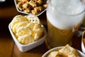 Set of various snacks, pint of lager beer in a glass, a standard set of drinking and eating in a pub