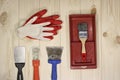 Set of various working painting tools - spatulas, brush, tray and work gloves on a light wooden background with copy space Royalty Free Stock Photo