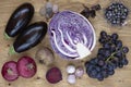 Set of vegetables and berries on aged wooden background: onion, eggplant, cabbage, beetroot, garlic, basil, grape, black currant.