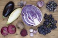 Set of vegetables and berries on aged wooden background: onion, eggplant, cabbage, beetroot, garlic, grape, black currant.