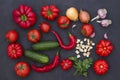 Set of vegetables on a black background: tomatoes, cucumbers, peppers, garlic, onions and parsley Royalty Free Stock Photo