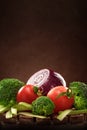 Set of vegetables on wooden stand on brown background. The concept of healthy eating with copy space.