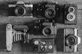 Set of vintage film camera from the times of the USSR on a wooden background, closeup, top view. Line of old retro cameras. Black Royalty Free Stock Photo