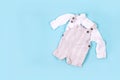 Set of warm baby clothes with bodysuits for boy on blue background. Collection of cute baby clothes. Gift for the birth of a boy