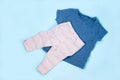 Set of warm baby clothes with bodysuits for boy on blue background. Collection of cute baby clothes. Gift for the birth of a boy