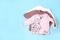 Set of warm baby clothes with bodysuits for boy on blue background. Collection of cute baby clothes. Gift for the birth of a boy